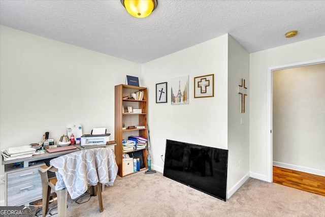 office space with light carpet and a textured ceiling