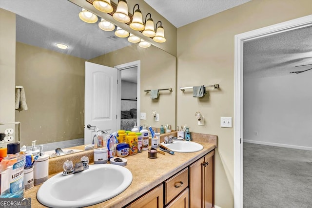 bathroom with a textured ceiling and double sink vanity