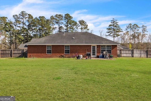 rear view of property featuring a lawn and a patio area