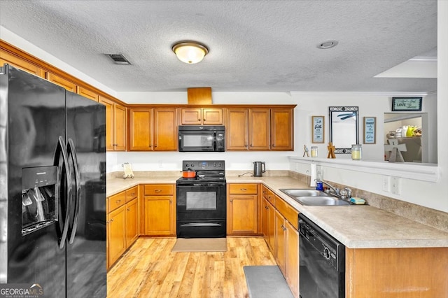 kitchen featuring black appliances, light hardwood / wood-style floors, sink, a textured ceiling, and crown molding