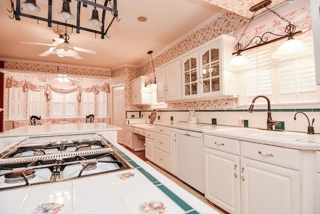 kitchen with tile counters, white cabinets, ceiling fan, sink, and white dishwasher