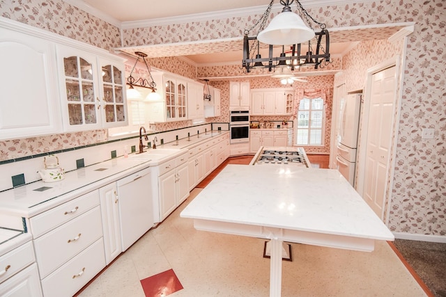 kitchen with white appliances, white cabinetry, decorative light fixtures, and sink