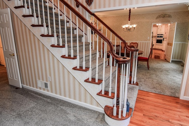 staircase with carpet and an inviting chandelier