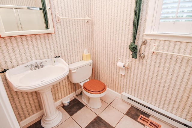 bathroom with tile flooring, toilet, and a baseboard heating unit