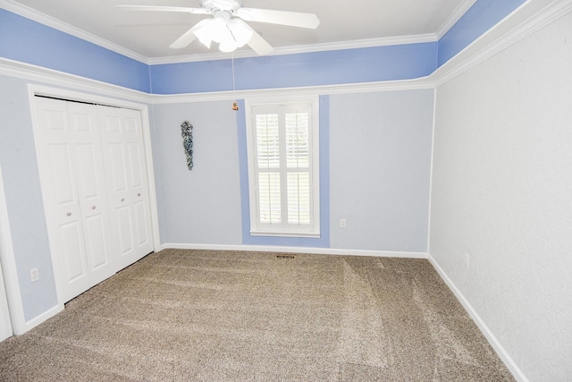 unfurnished bedroom featuring ceiling fan, ornamental molding, dark colored carpet, and a closet