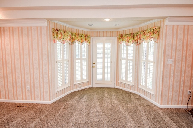 carpeted spare room featuring crown molding and a healthy amount of sunlight