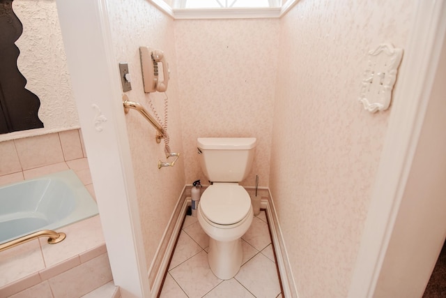 bathroom featuring a tub, toilet, and tile floors