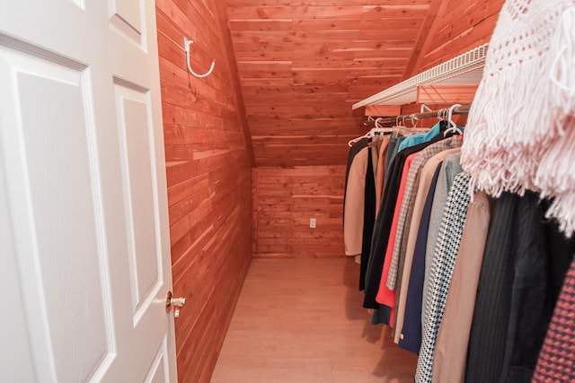 spacious closet featuring light hardwood / wood-style floors and vaulted ceiling