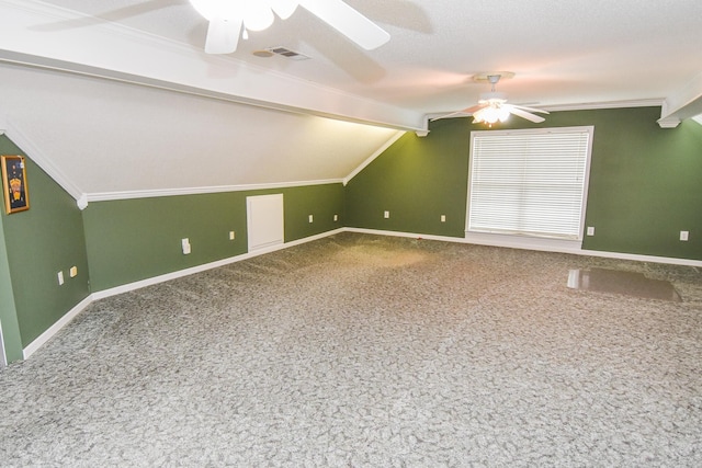 additional living space with carpet flooring, a textured ceiling, vaulted ceiling with beams, and ceiling fan