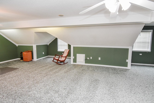 bonus room with ceiling fan, lofted ceiling, light colored carpet, and a textured ceiling