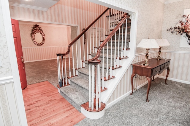 staircase with ornamental molding and carpet floors