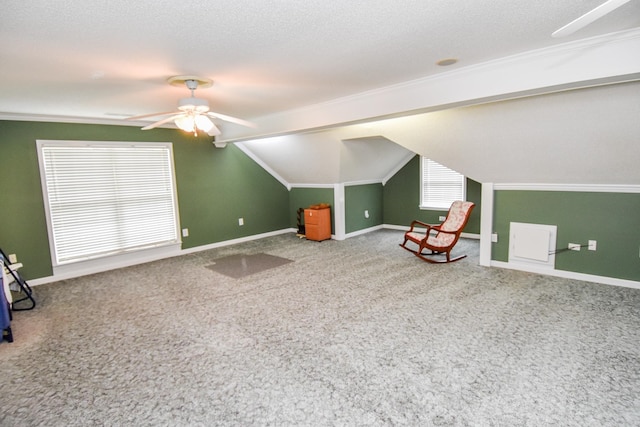 additional living space featuring ceiling fan, a textured ceiling, light colored carpet, and vaulted ceiling