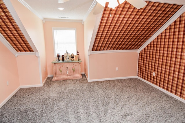 additional living space with a textured ceiling, ceiling fan, and light colored carpet