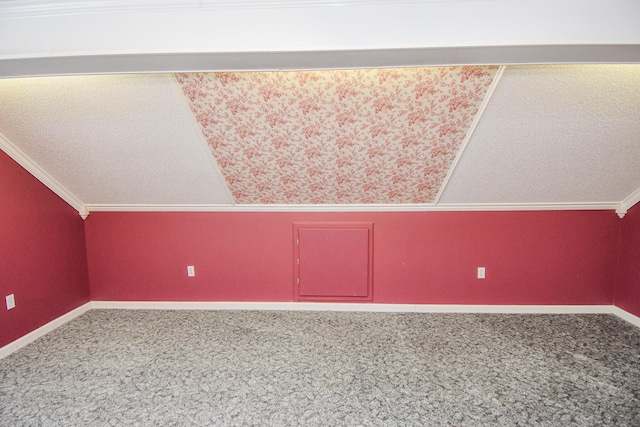 additional living space with lofted ceiling, a textured ceiling, and carpet floors