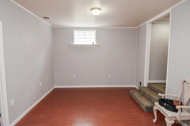 basement featuring dark wood-type flooring and crown molding