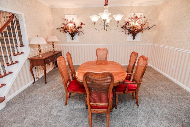 carpeted dining space featuring a notable chandelier and ornamental molding