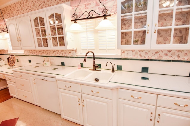 kitchen with decorative light fixtures, tasteful backsplash, white cabinetry, sink, and white dishwasher