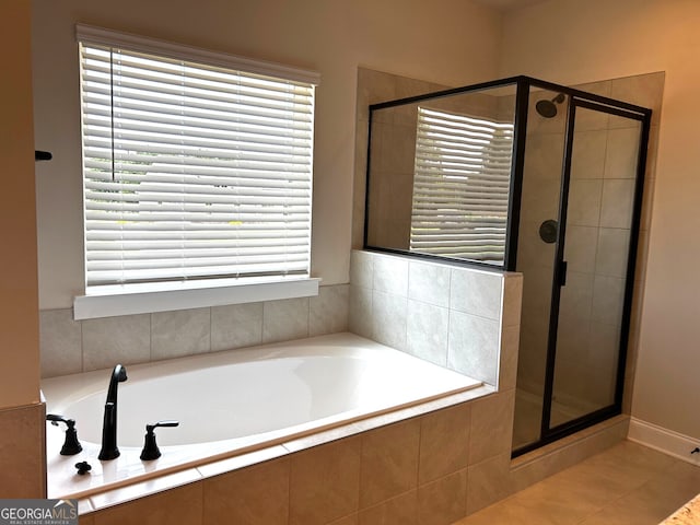 full bathroom featuring a garden tub, a shower stall, and tile patterned floors