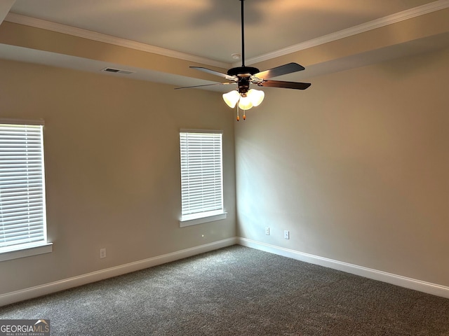 carpeted empty room featuring a ceiling fan, crown molding, and baseboards