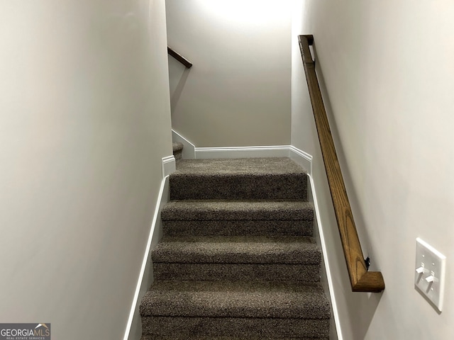 staircase featuring carpet floors and baseboards