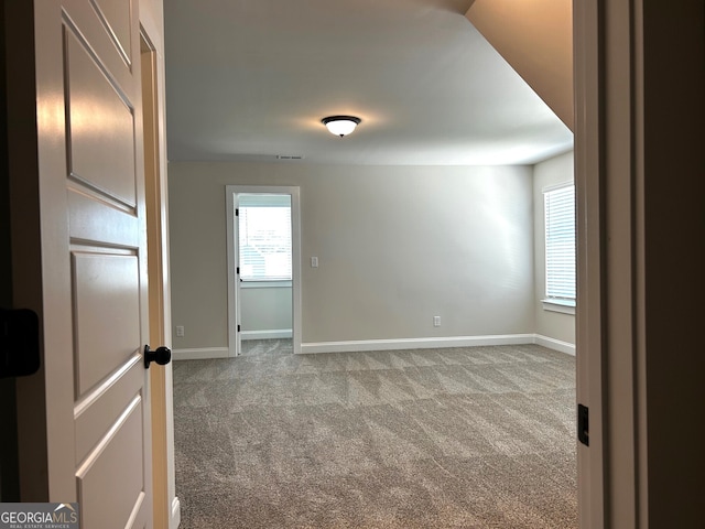 unfurnished room featuring carpet, visible vents, and baseboards