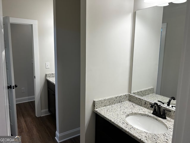 bathroom with vanity, baseboards, and wood finished floors