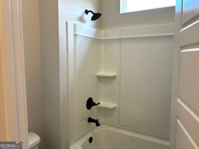 bathroom with toilet and washtub / shower combination