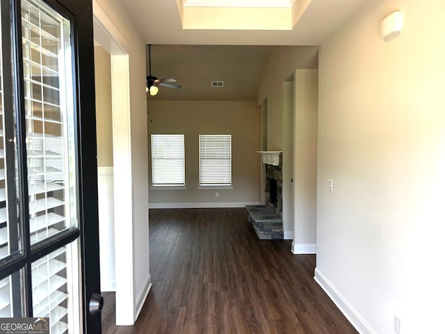 hallway featuring dark wood-style flooring, visible vents, and baseboards