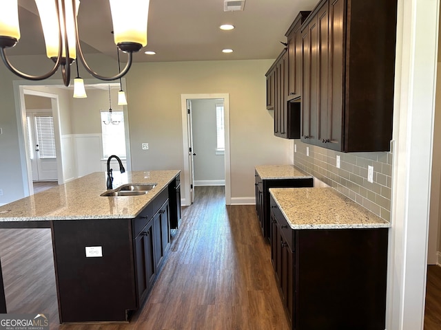 kitchen featuring dark wood finished floors, recessed lighting, decorative backsplash, a sink, and dark brown cabinets