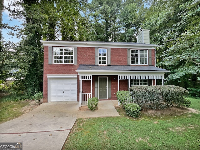 view of front of property featuring a garage, covered porch, and a front yard