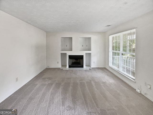 unfurnished living room with a textured ceiling and carpet floors