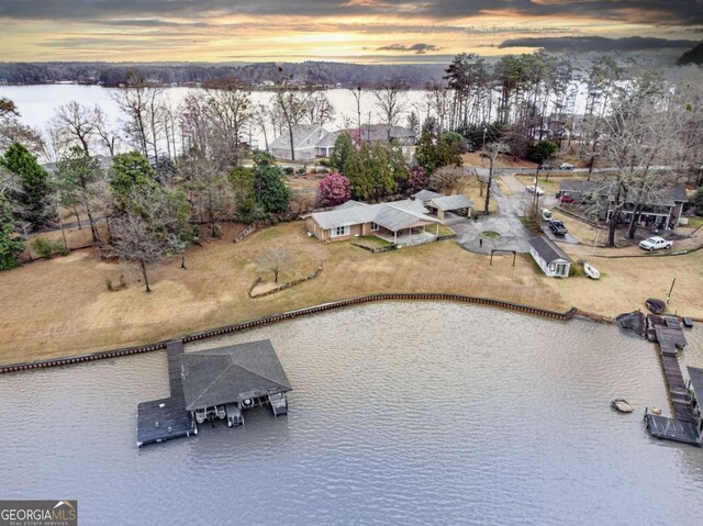 aerial view at dusk featuring a water view