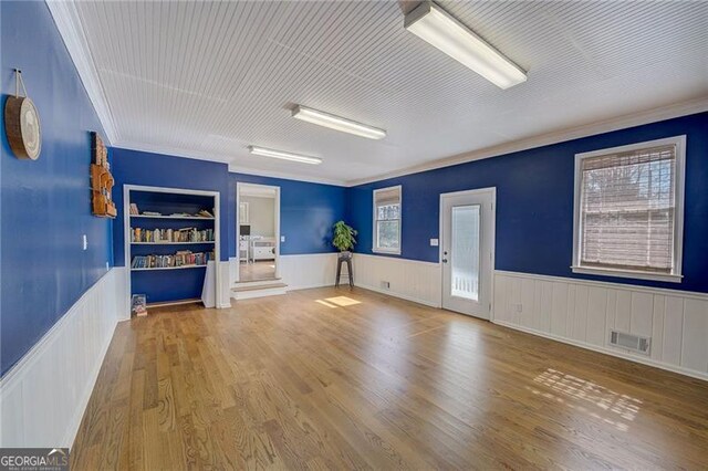 interior space with ornamental molding and hardwood / wood-style flooring