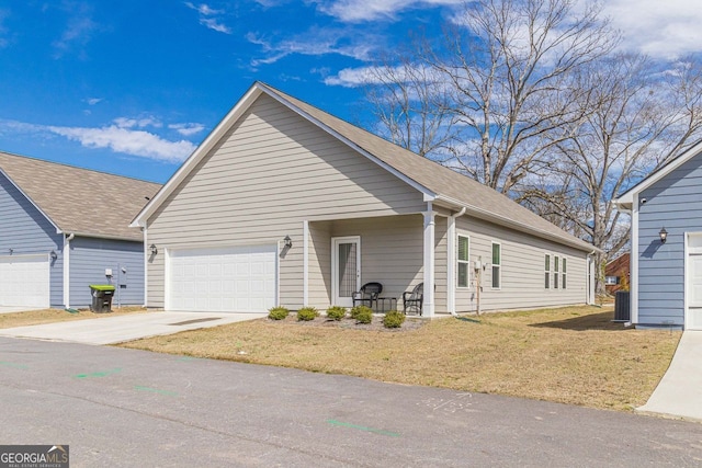 view of front of house with central air condition unit, a front lawn, and a garage