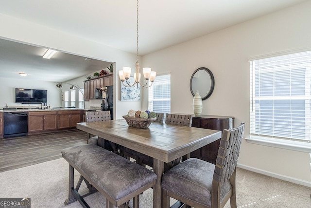 dining space with a notable chandelier and dark colored carpet