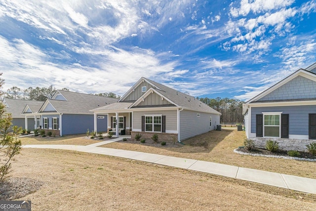 craftsman-style house featuring covered porch and a front yard