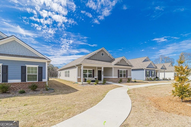 craftsman-style home with covered porch and a front lawn