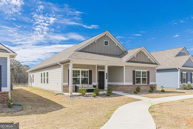 craftsman-style home with a front lawn and covered porch