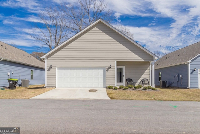 view of front of house featuring a front lawn, central air condition unit, and a garage