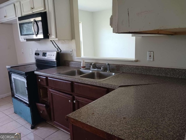 kitchen with light tile floors, dark brown cabinets, white cabinets, electric range oven, and sink