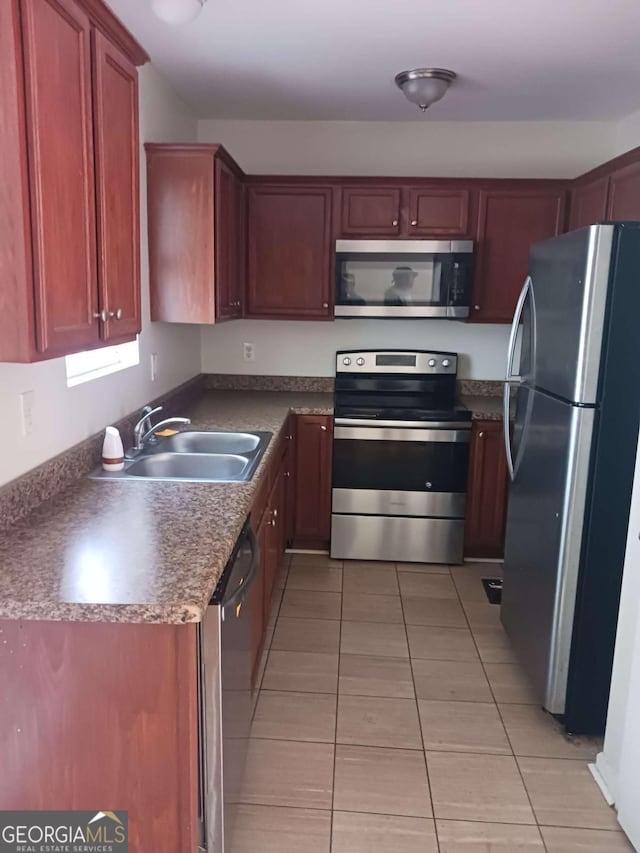 kitchen featuring light tile floors, appliances with stainless steel finishes, and sink