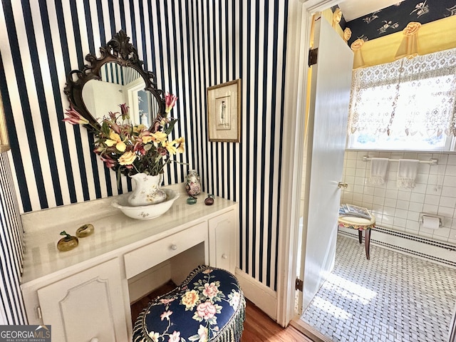 bathroom with tile walls, hardwood / wood-style floors, and vanity