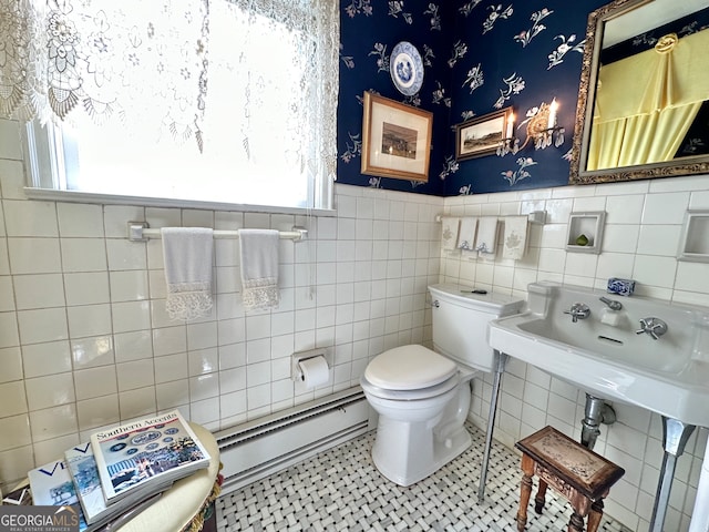 bathroom featuring tile walls, baseboard heating, toilet, and tile flooring