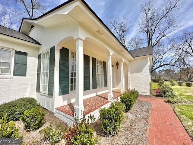 view of side of home featuring covered porch