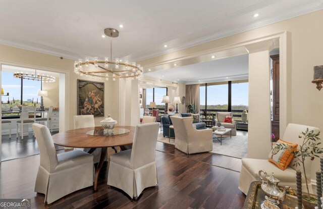 dining area with ornamental molding, dark hardwood / wood-style flooring, and an inviting chandelier