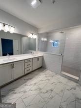 bathroom with tile flooring, double sink, tiled shower, and oversized vanity