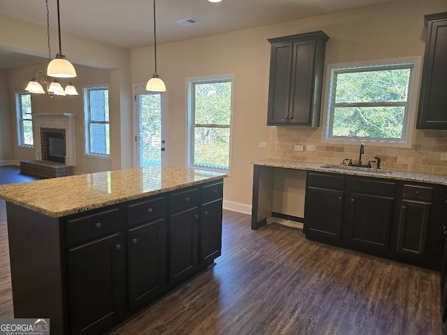 kitchen featuring pendant lighting, a center island, dark wood-type flooring, and tasteful backsplash