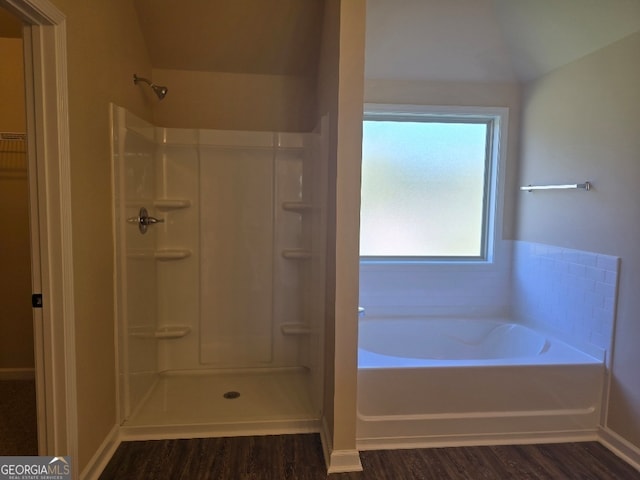 bathroom with vaulted ceiling, plus walk in shower, and hardwood / wood-style floors