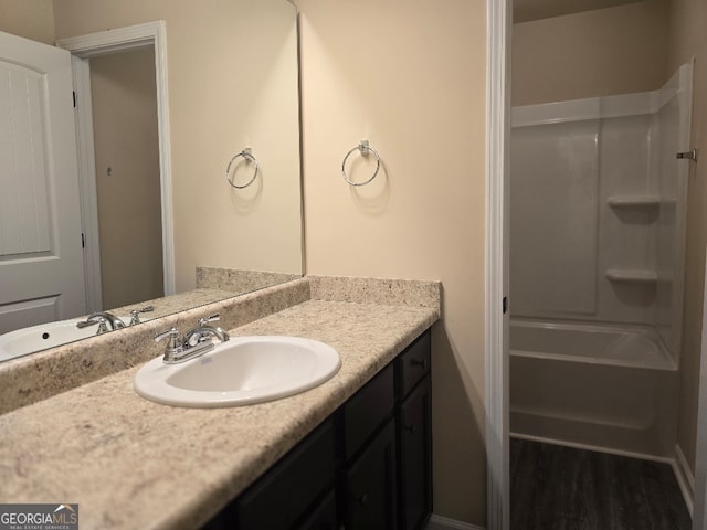 bathroom with wood-type flooring, vanity, and shower / tub combination