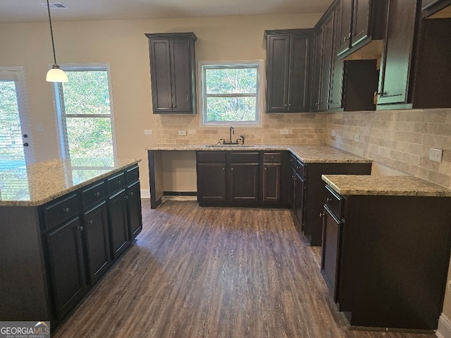 kitchen featuring decorative light fixtures, dark wood-type flooring, sink, and a wealth of natural light